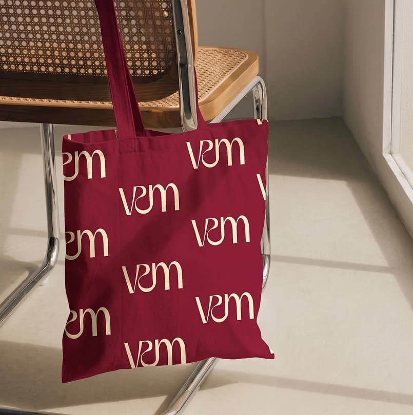Bolsa borgoña con monogramas de Veritomom junto a una silla